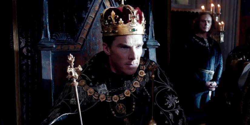 Benedict Cumberbatch sits on a throne wearing a crown and holding a scepter in The Hollow Crown. 