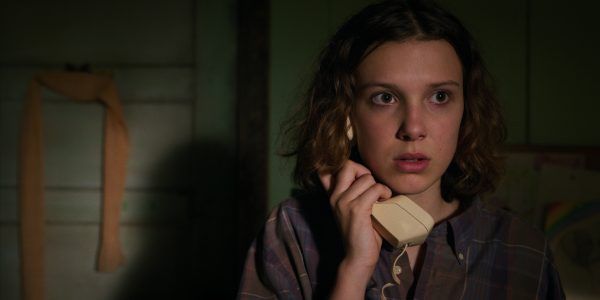Eleven from Stranger Things on the phone, looking scared.