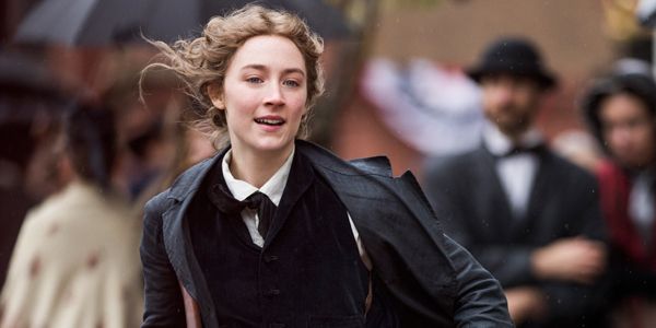 Jo March (Saoirse Ronan) runs through a busy street in 18th century America. 