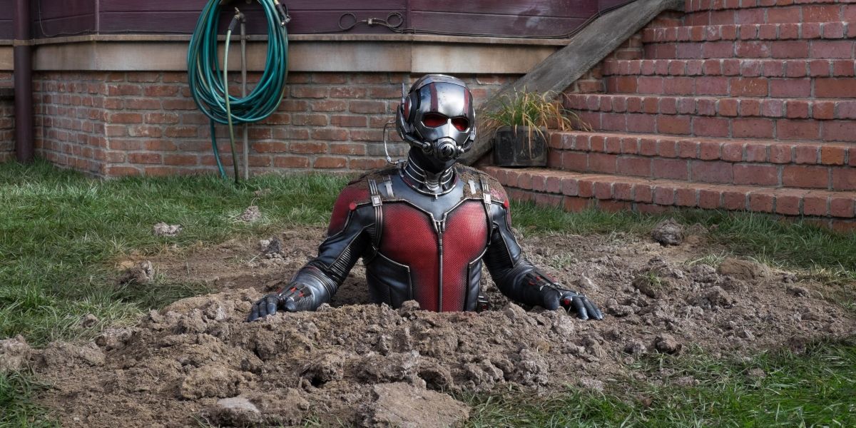Ant-Man half submerged in a hole in a backyard