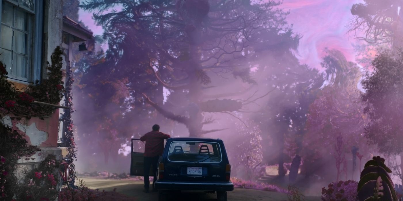 A man stands in the door of his car as a mysterious purple glow glistens over his property.