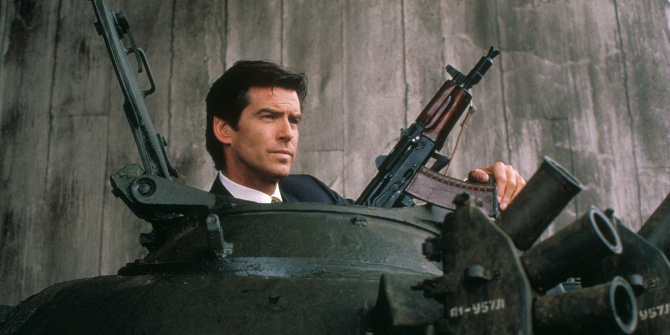Pierce Brosnan as James Bond with a pile of guns