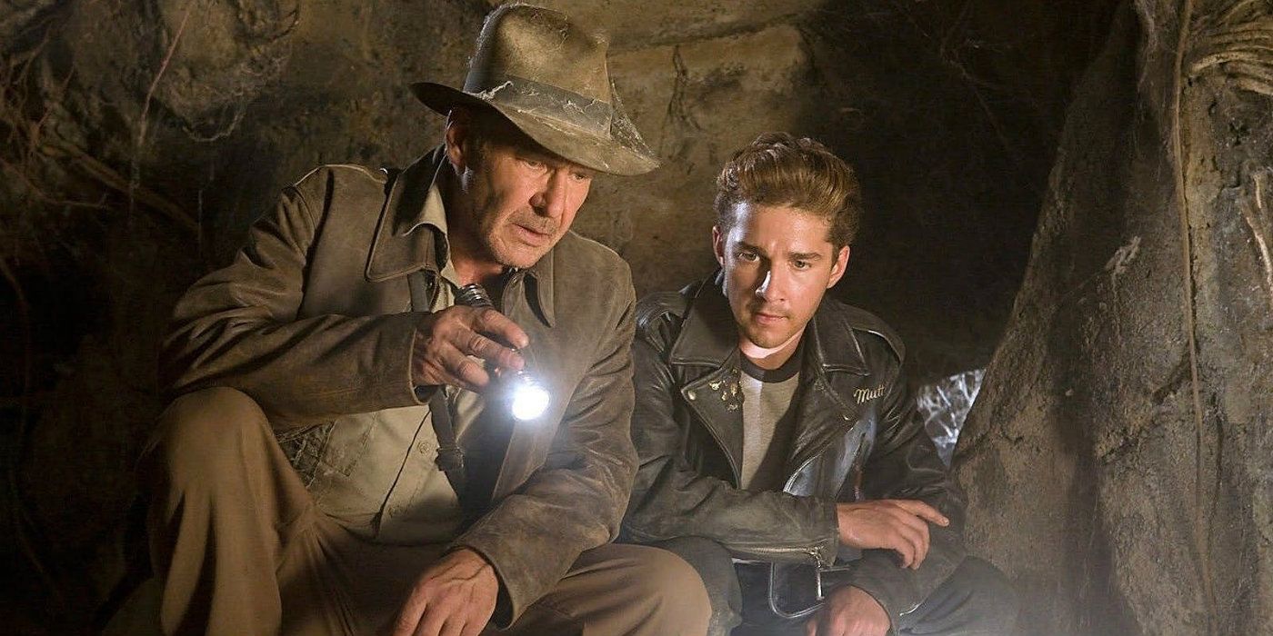 Harrison Ford as Indiana Jones and Shia LaBeouf as Mutt shining a flashlight on something in a cave