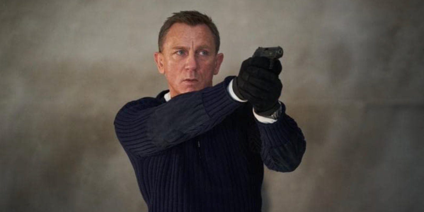 Daniel Craig as James Bond aiming a gun at something off-camera in No Time to Die