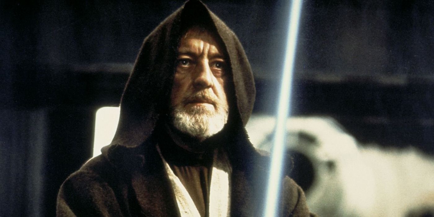 Alec Guinness as Obi-Wan Kenobi holding a lightsaber in Star Wars