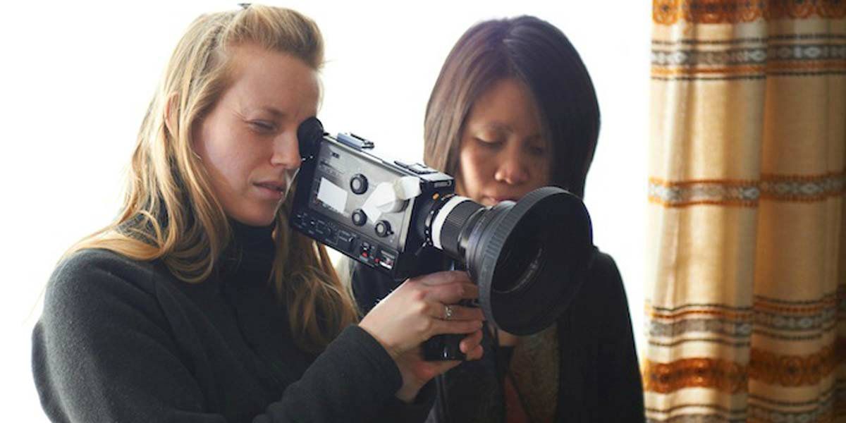 Uma foto bts de Sarah Polley com uma câmera de filme.