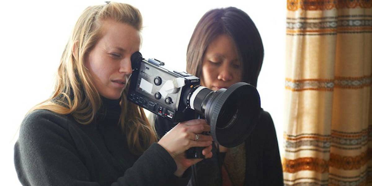 A bts shot of Sarah Polley with a film camera.