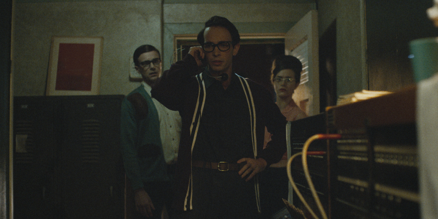 A group of people stand near a phone switchboard
