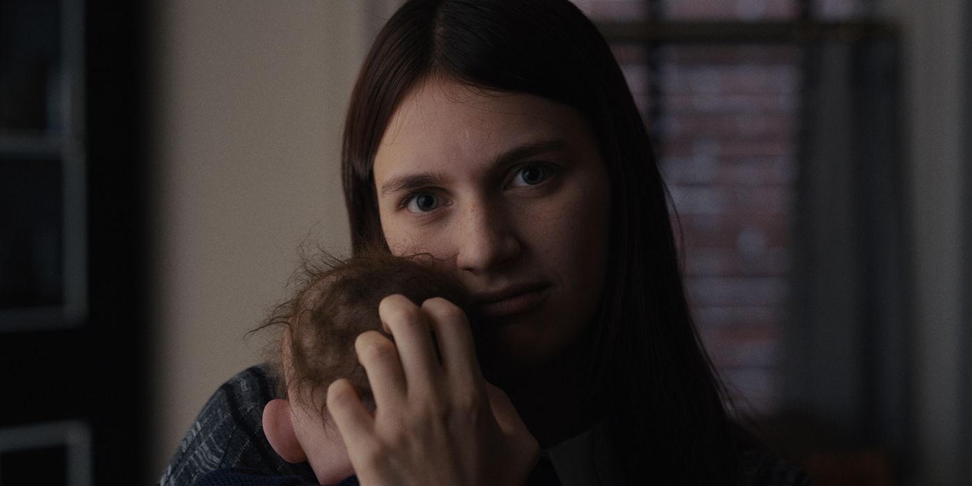 Leanne Grayson as Nell holding a baby in Servant