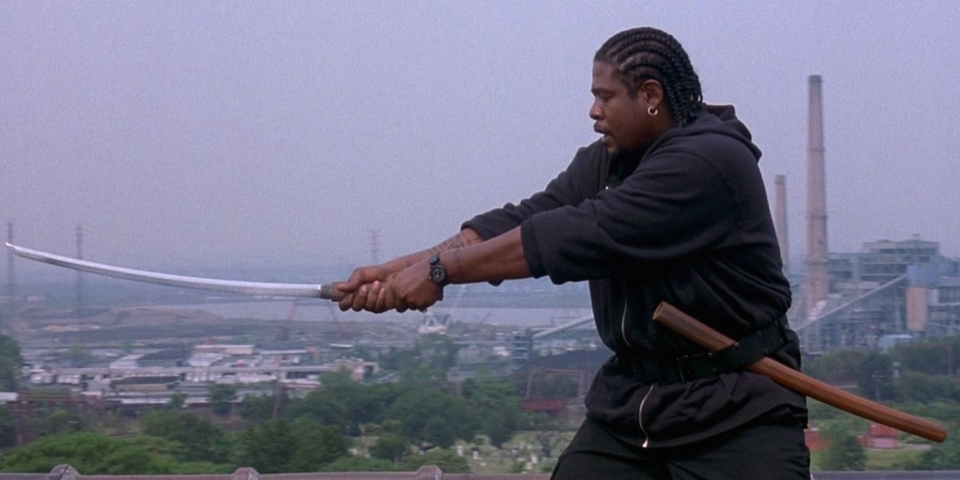 Forest Whitaker holds a Samurai sword with a city landscape in the background in Ghost Dog: The Way of the Samurai.