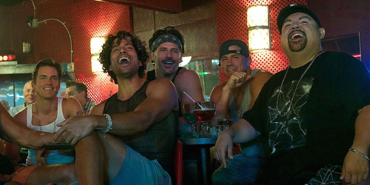 The cast of Magic Mike XXL sit at a bar and laugh together in Magic Mike XXL.