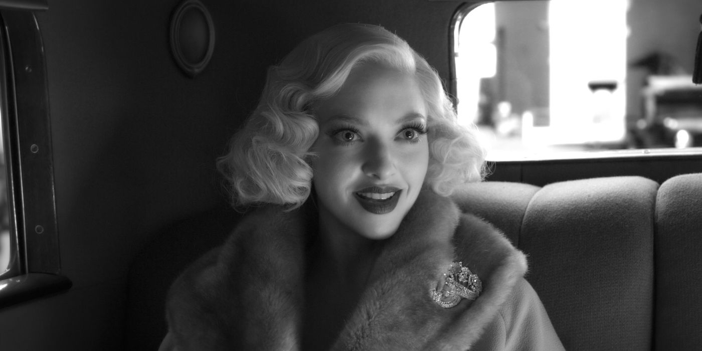 Amanda Seyfried as Marion Davies smiling while sitting on the backseat of a car in Mank.