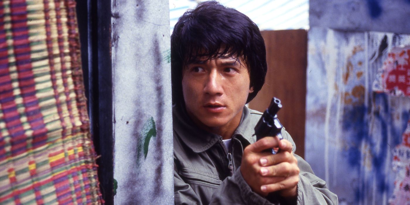 Jackie Chan holding a gun hiding behind some hanging clothes in Police Story.