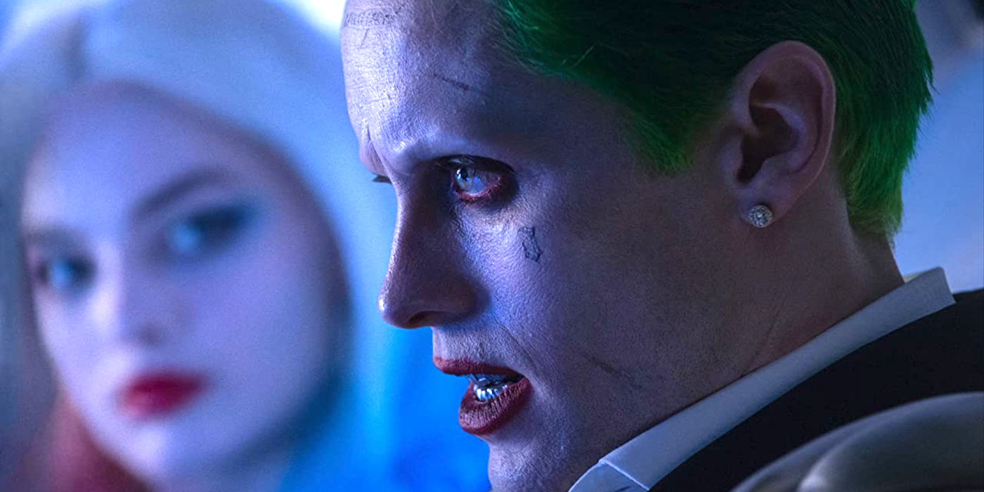 Jared Leto as the Joker, staring forward while Harley Quinn (Margot Robbie) looks at him in Suicide Squad