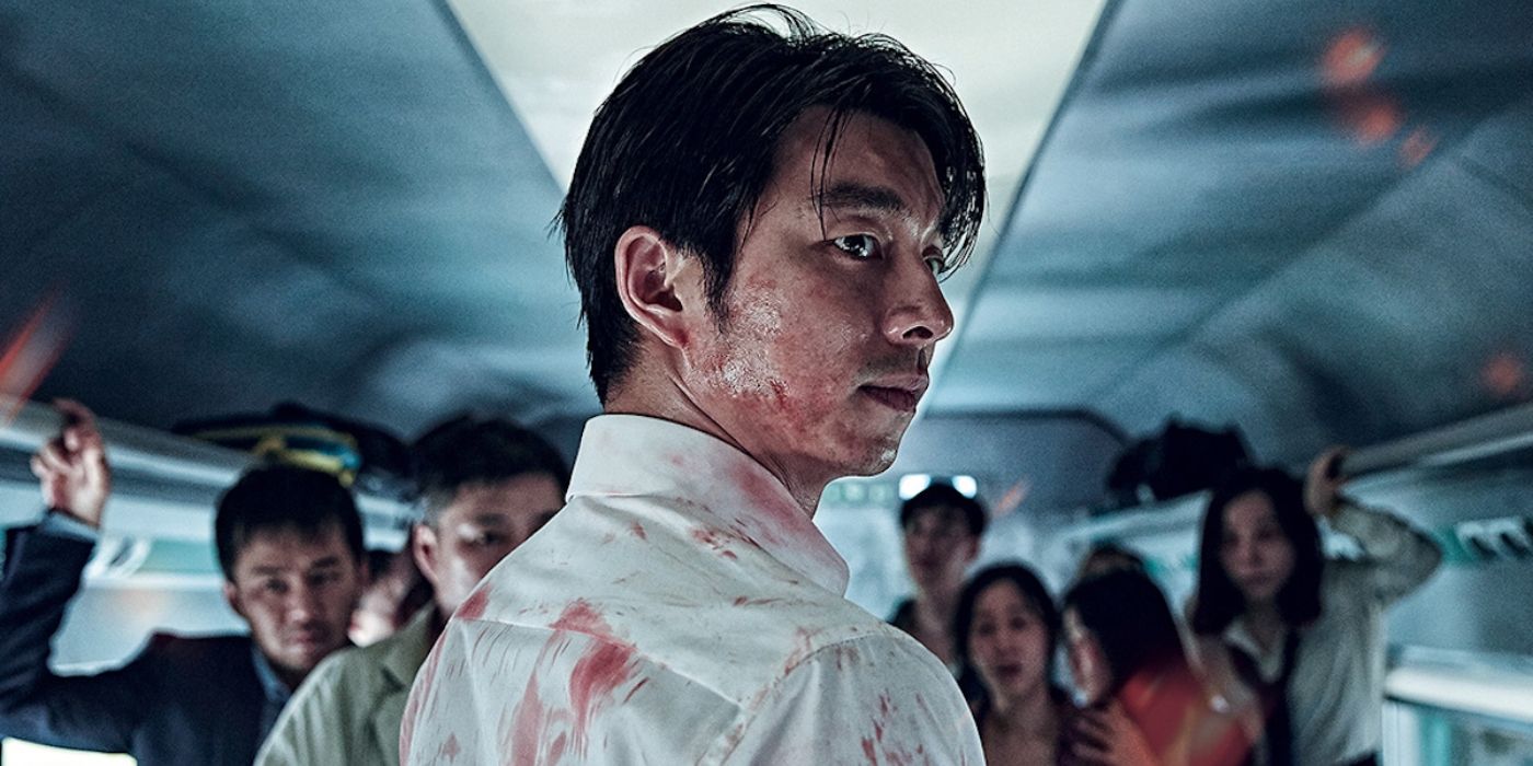 A man covered in blood turns around while a train full of passgengers stand in front of him inTrain to Busan
