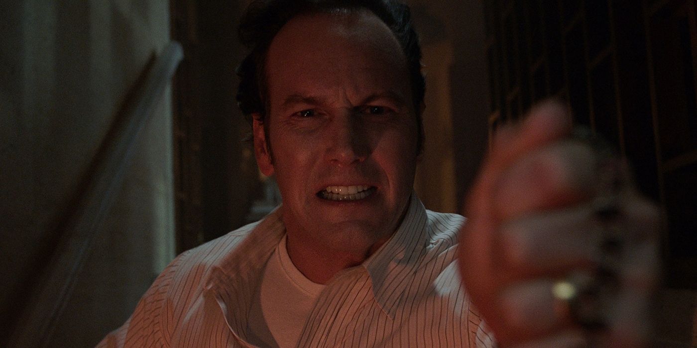 Patrick Wilson as Ed Warren holding up a cross at the camera in The Conjuring 3