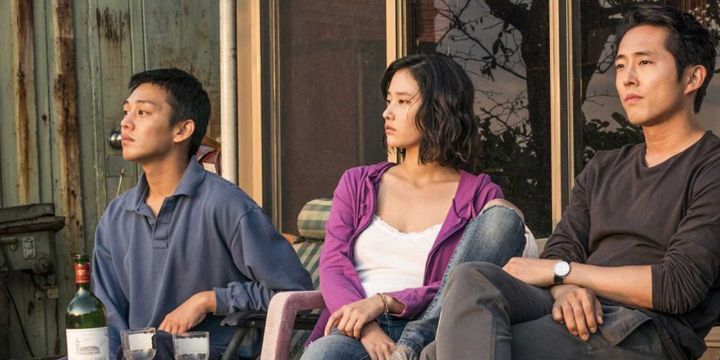 Jooh Ah-In as Lee, Jeon Jong-Seo as Shin and Stephen Yeun as Ben sitting on a porch in &lsquo;Burning&rsquo;