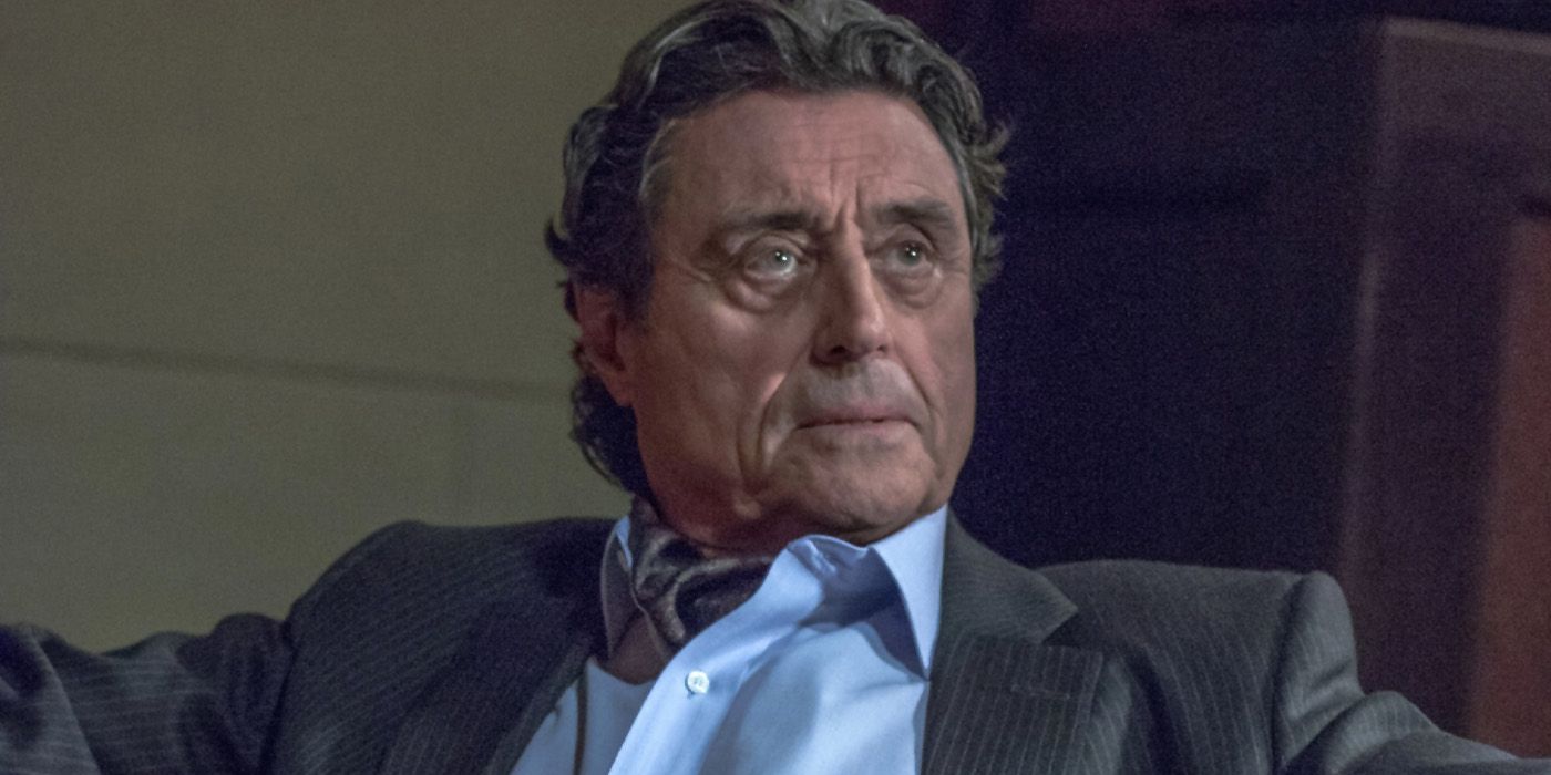 Ian McShane as Winston sitting in a chair and looking at a character offscreen in john Wick 3: Parabellum