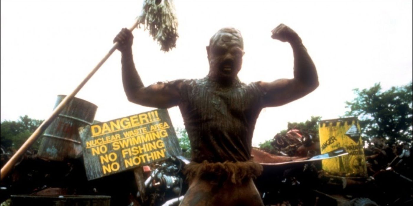 The Toxic Avenger flexing with a mop in the film The Toxic Avenger