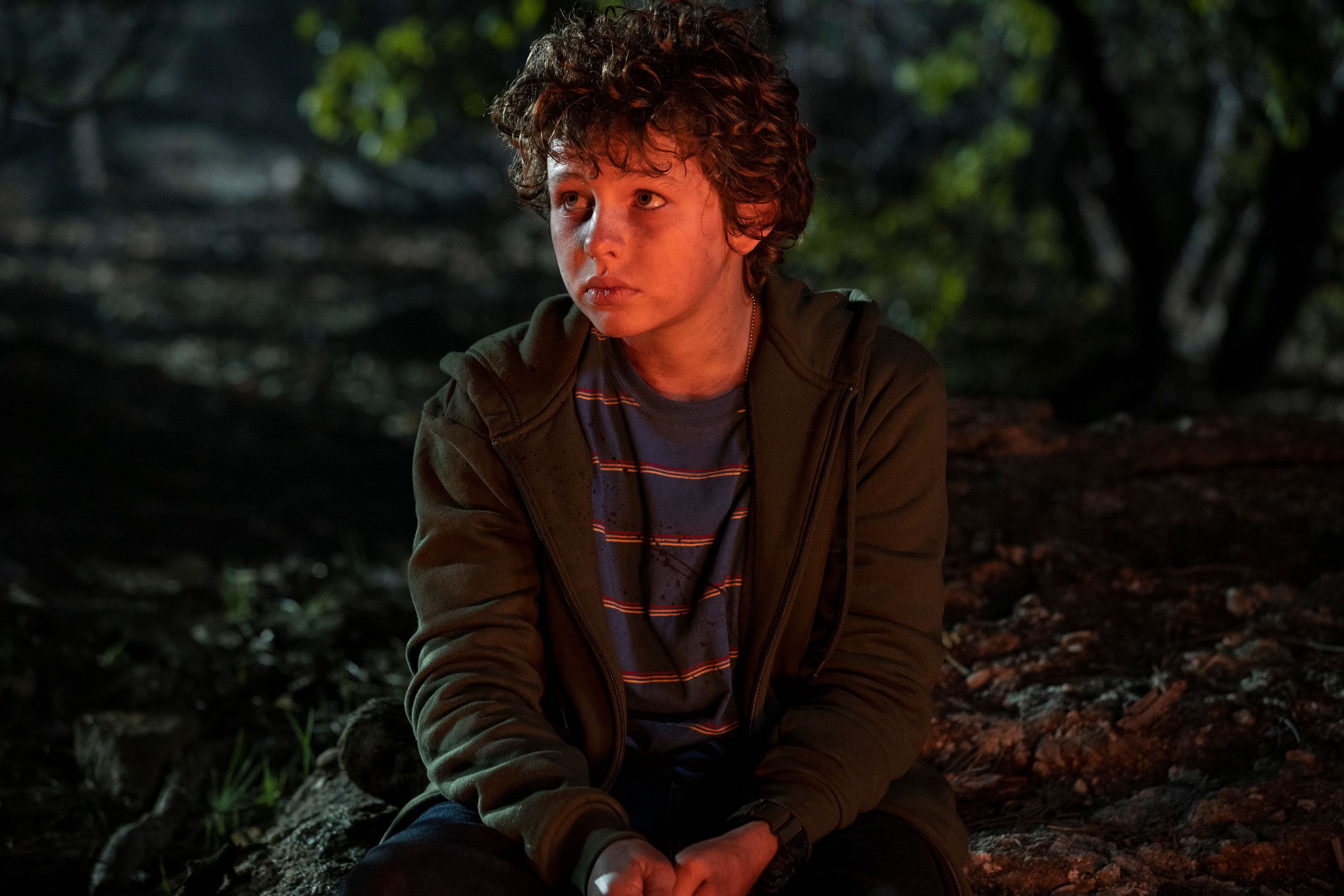 Finn Little sitting in the woods in Taylor Sheridan's Those Who Wish Me Dead.