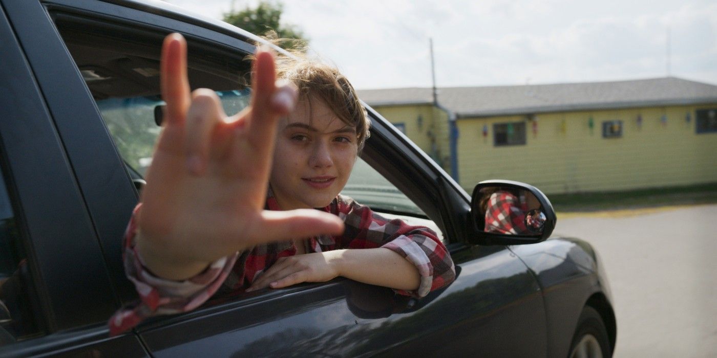 A girl in a car using sign language