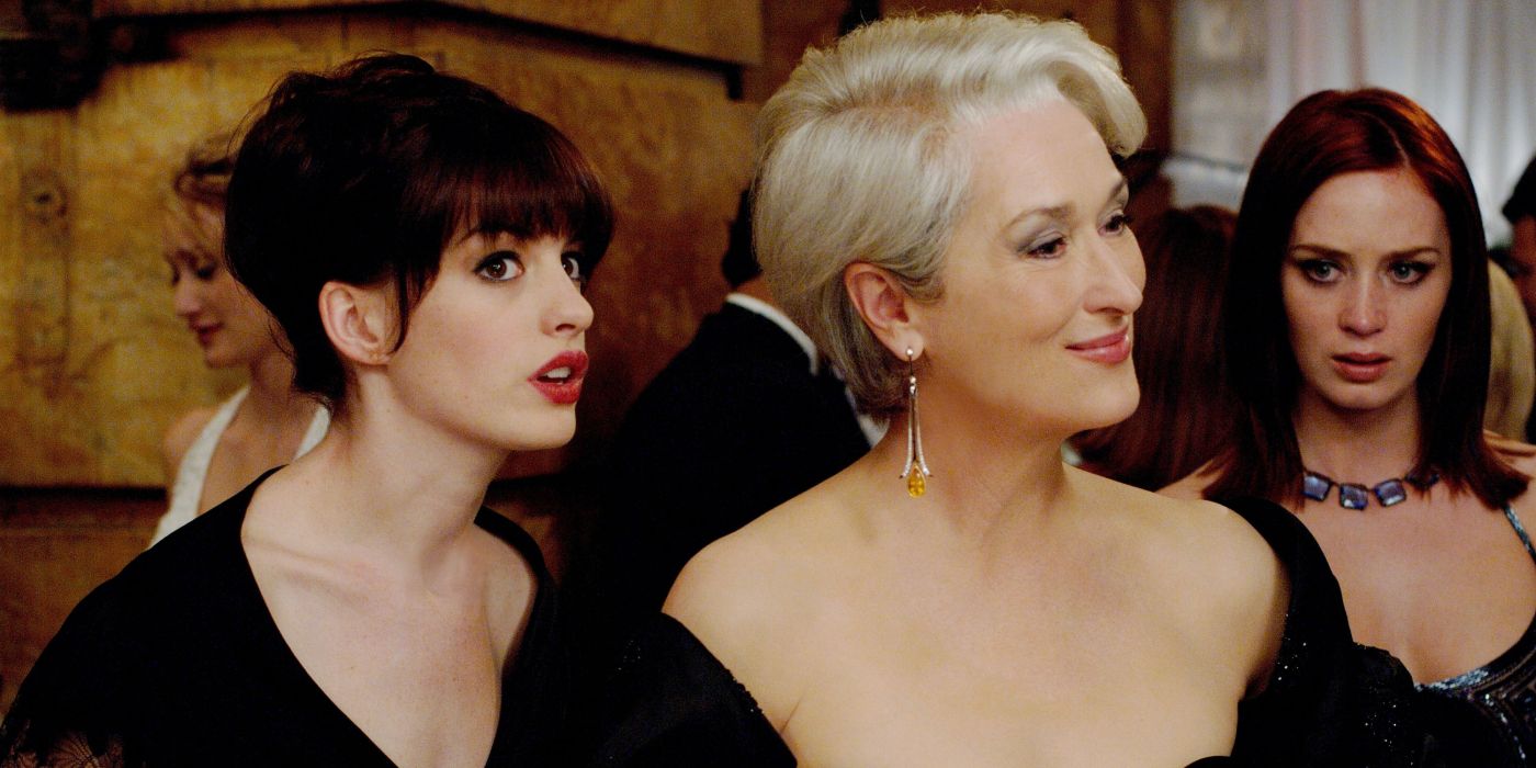 Anne Hathaway, Meryl Streep, and Emily Blunt standing together at a party in The Devil Wears Prada