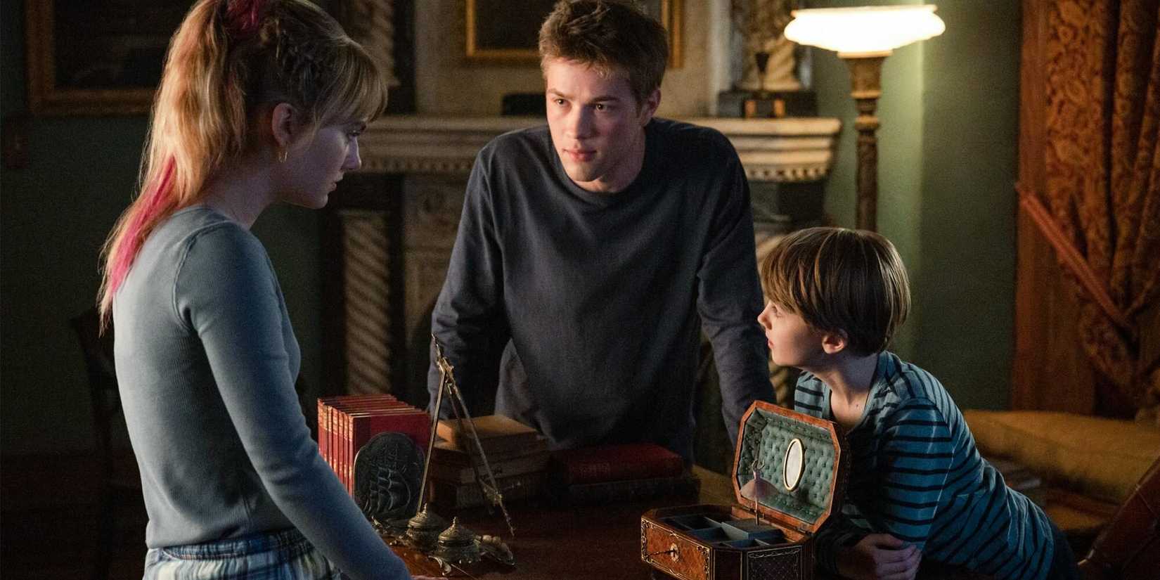 Three of the cast members (Darby Stanchfield, Connor Jessup, Emilia Jones) gather around a music box and look anxious in Locke & Key.