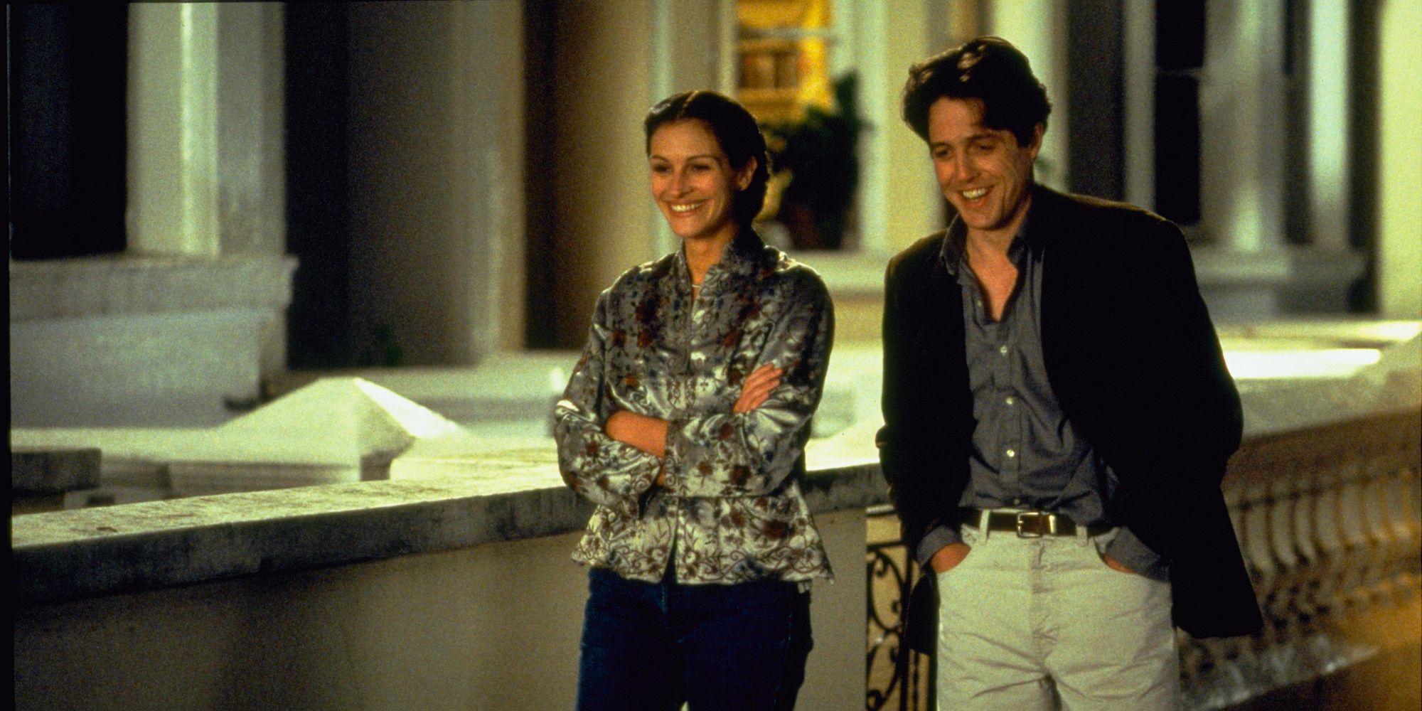 Anna and William laughing while walking down the street at night in Notting Hill.