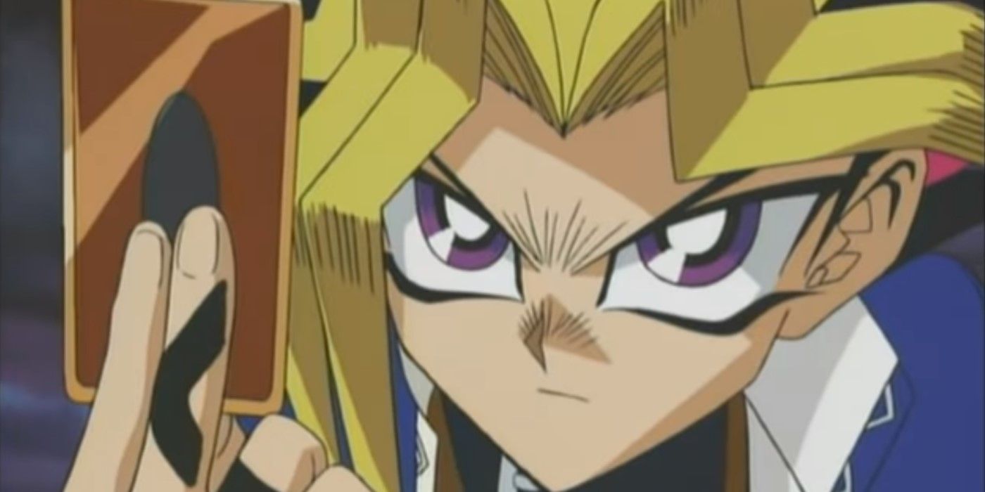 Yugi from Yugioh holding up a card and staring at his opponent