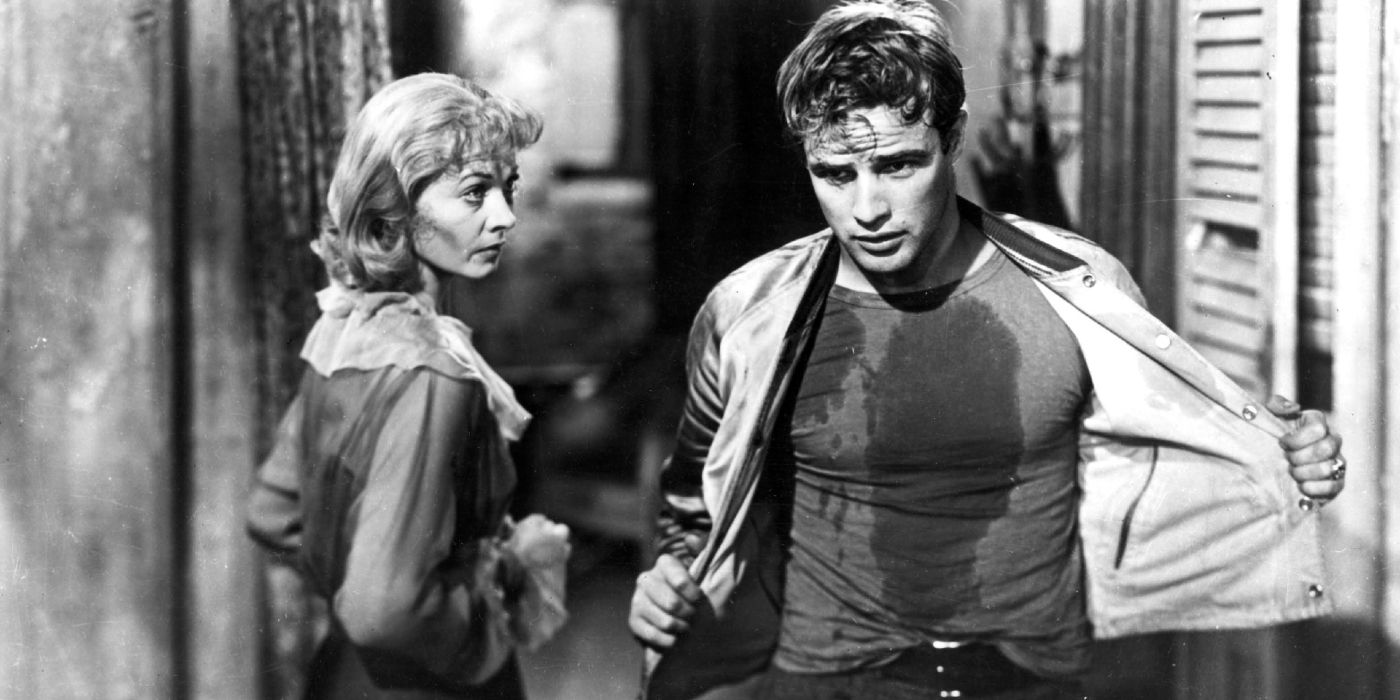 Vivien Leigh as Blanche DuBois and Marlon Brando as Stanley Kowalski covered in grease and removing his overshirt in A Streetcar Named Desire