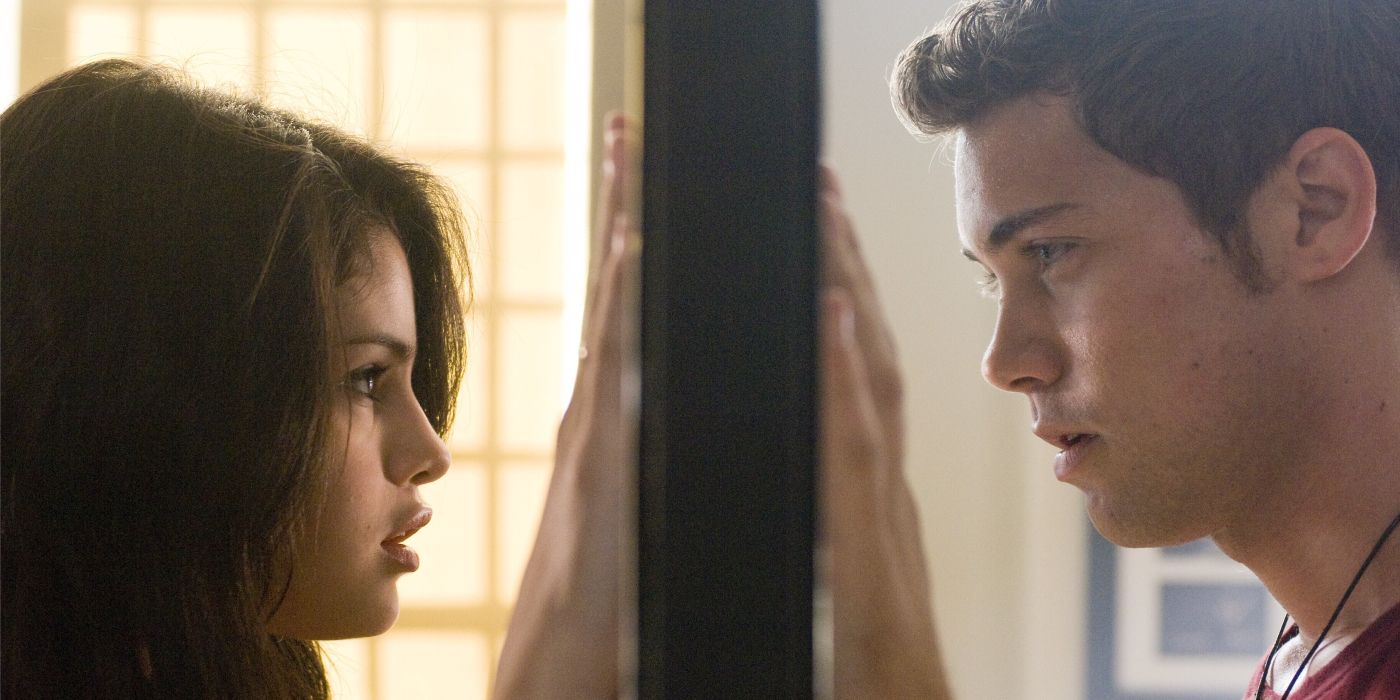 Selena Gomez as Mary and Drew Seeley as Joey Parker with their hands on a mirror looking at each other in Another Cinderella Story
