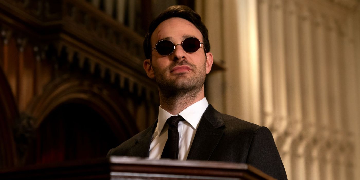 Charlie Cox as Matt Murdock in Daredevil, standing in a cathedral and donning his signature glasses