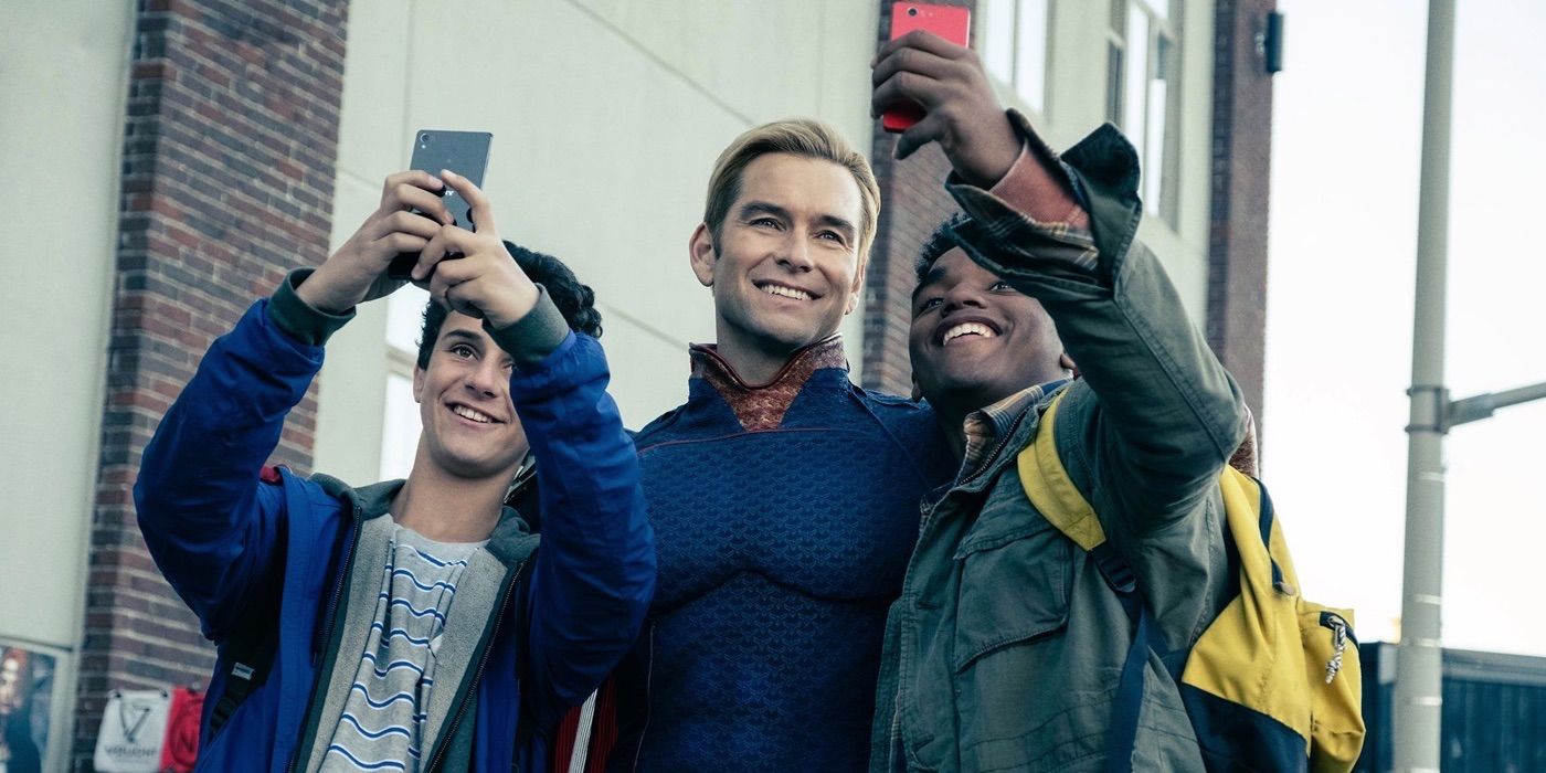 Homelander (Antony Starr) smiling and taking a selfie with two fans in The Boys