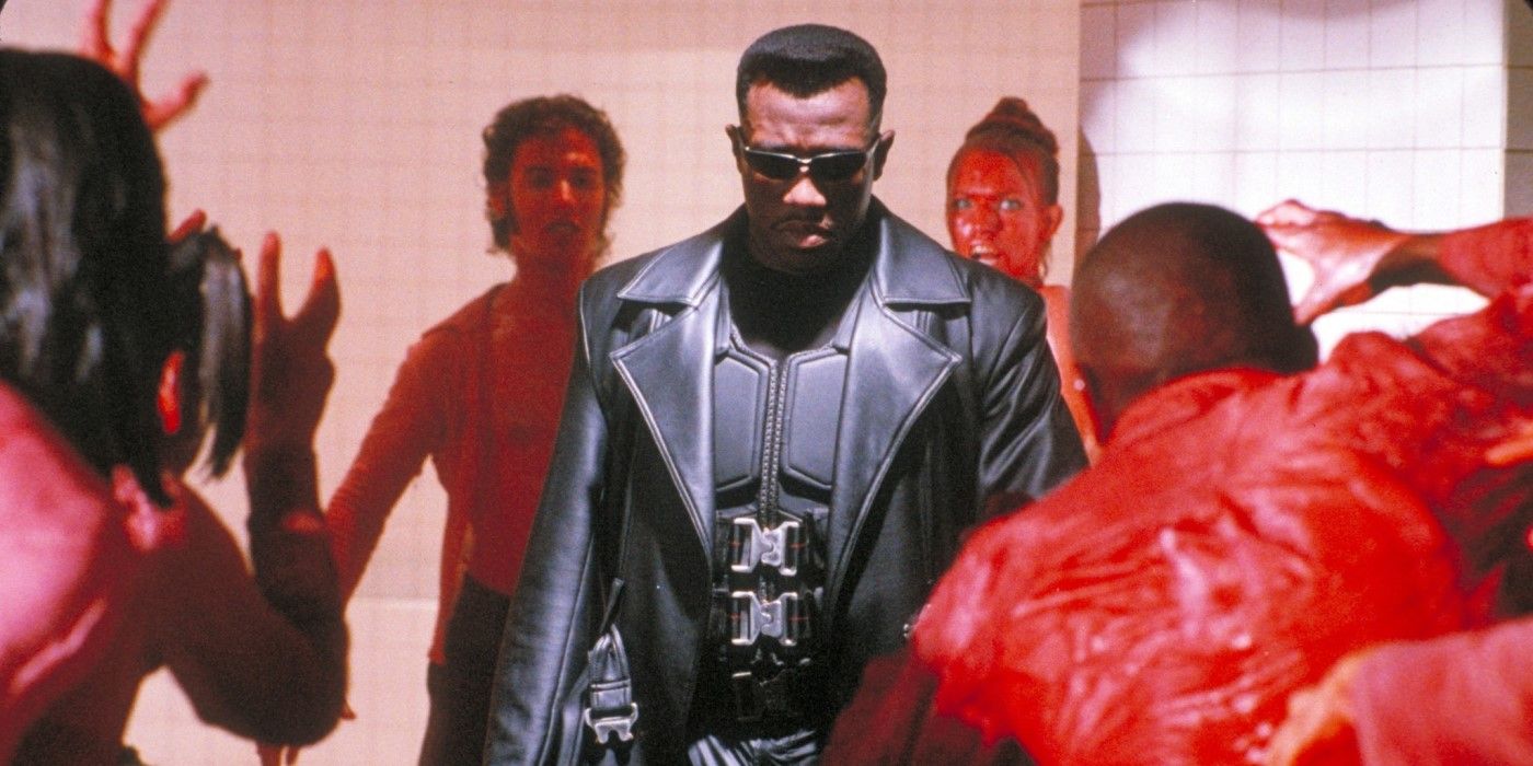 Blade, a vampire hunter, stands ready to fight in a room surrounded by blood-covered vampires. 