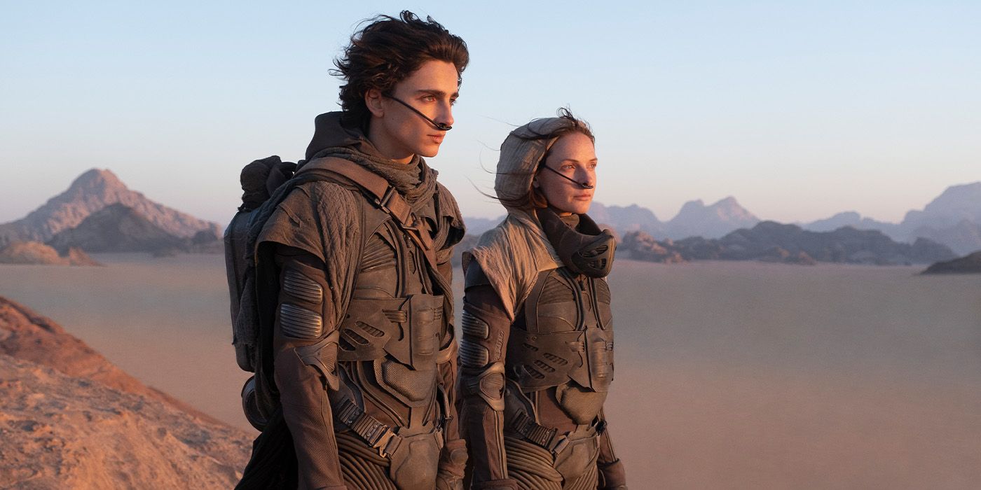Timothee Chalamet as Paul Atriedes and Rebecca Ferguson as Lady Jessica standing in a desert in Dune
