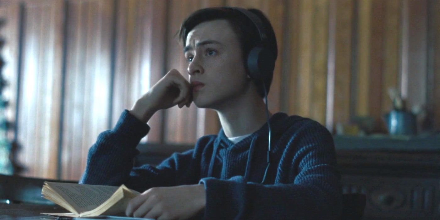 Jaeden Martell as Aidan Hall wearing headphones in the film The Lodge.