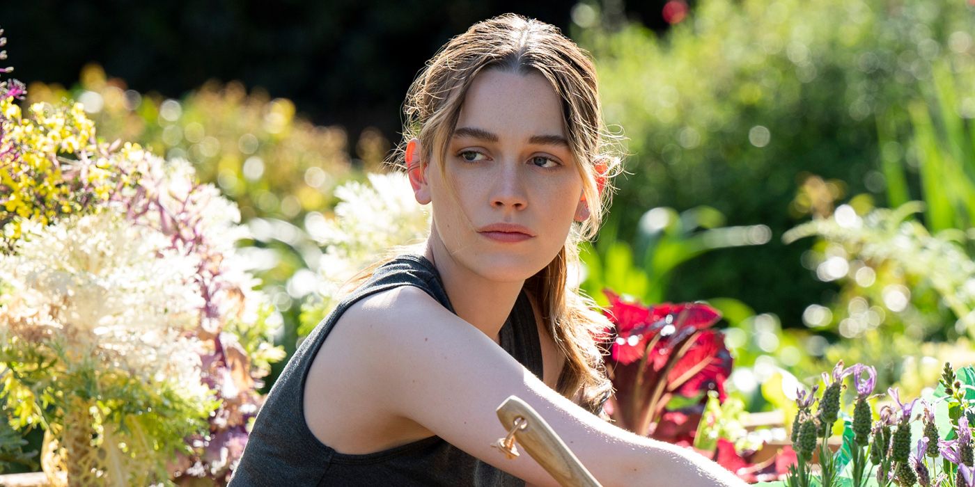 Victoria Pedretti as Love Quinn sitting in her garden in You Season 3