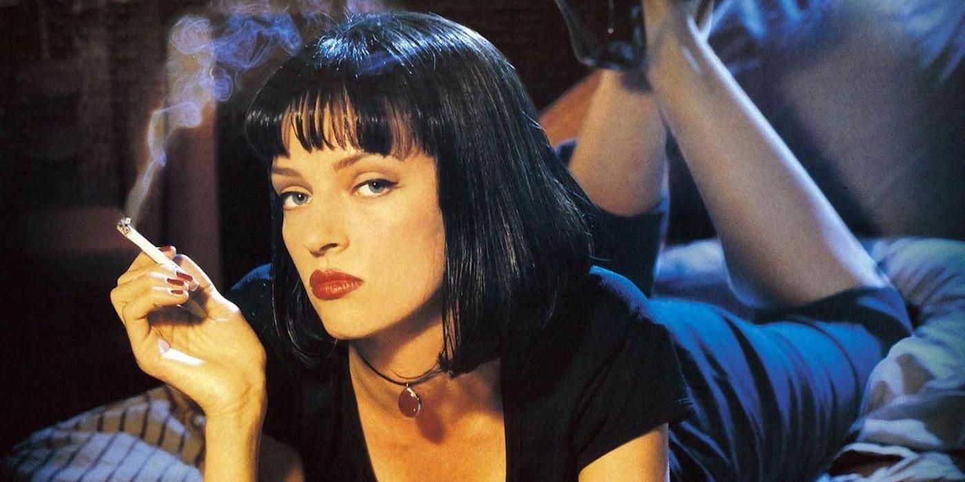 Uma Thurman smoking a cigarette while laying on a bed in Pulp Fiction