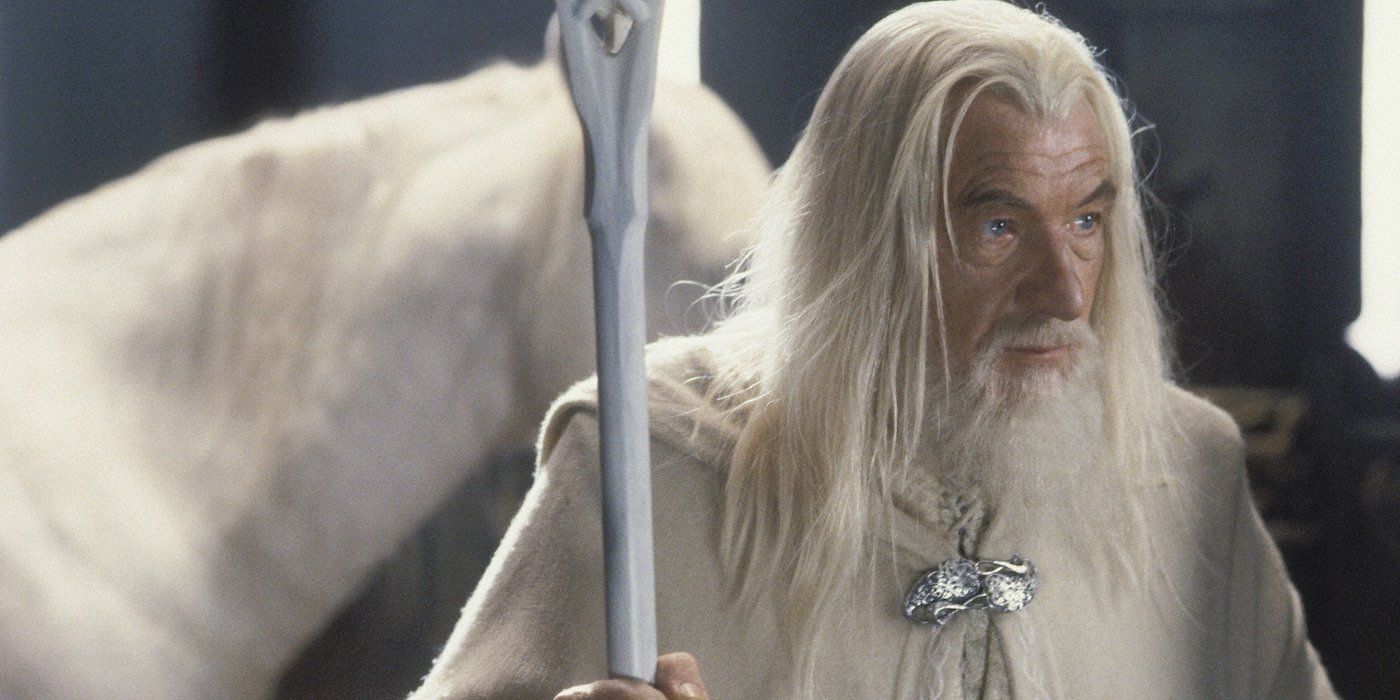 Ian McKellan as Gandalf the White holding his staff and standing in front of a white horse in Lord of the Rings