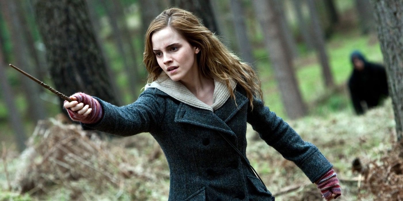 Hermione dans les bois, pointant sa baguette sur quelque chose hors champ dans Harry Potter et les reliques de la mort, partie 1.