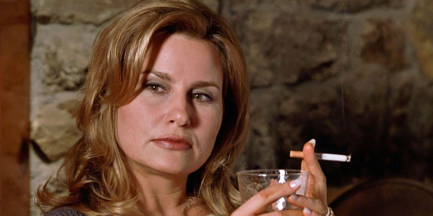 Jennifer Coolidge as Stifler's mom holding a cigarette and a glass while looking to her right in American Pie