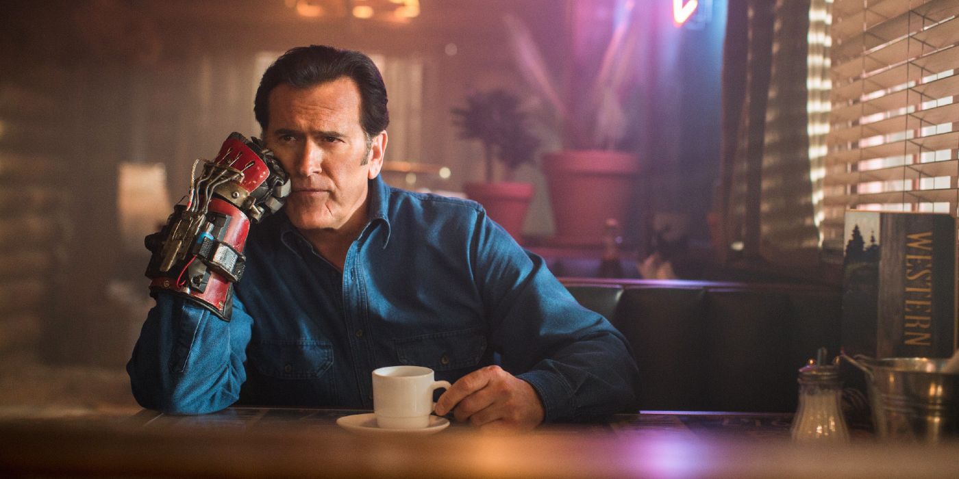 Ash, played by Bruce Campbell, sitting at the bar drinking coffee contemplatively in Ash vs Evil Dead
