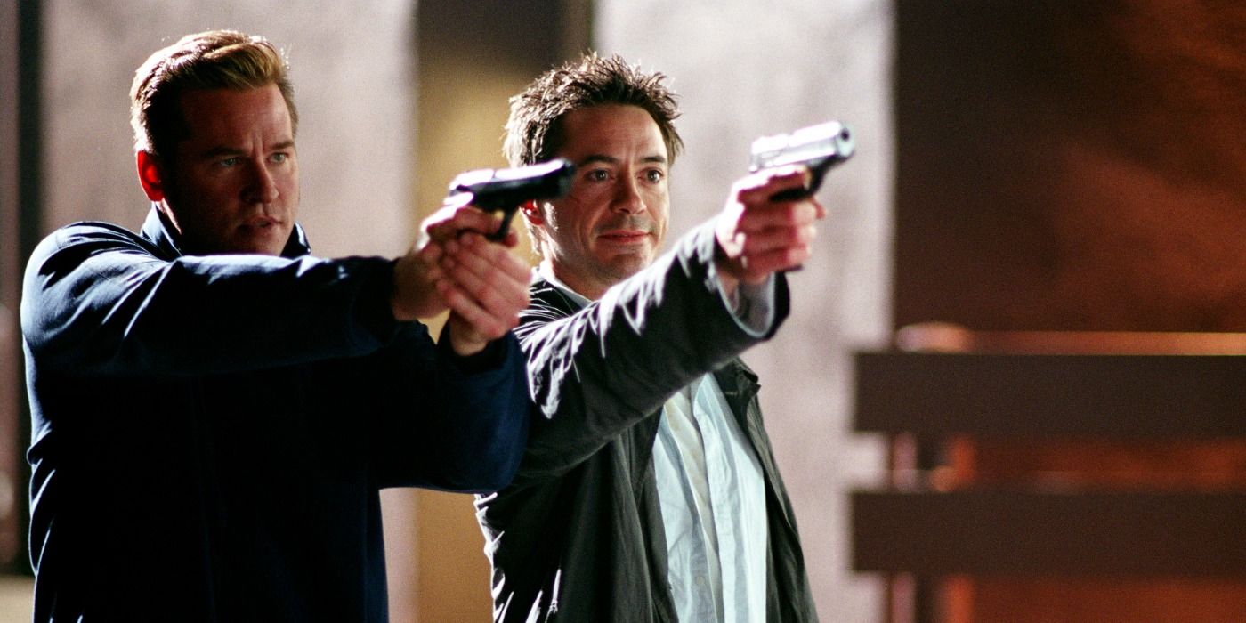 Val Kilmer et Robert Downey Jr. pointant des fusils dans la même direction dans le film Kiss Kiss Bang Bang