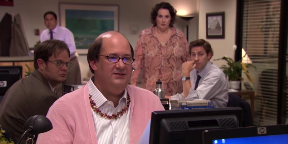 Kevin in Phyllis's clothing as Dunder Mifflin employees look on in The Office