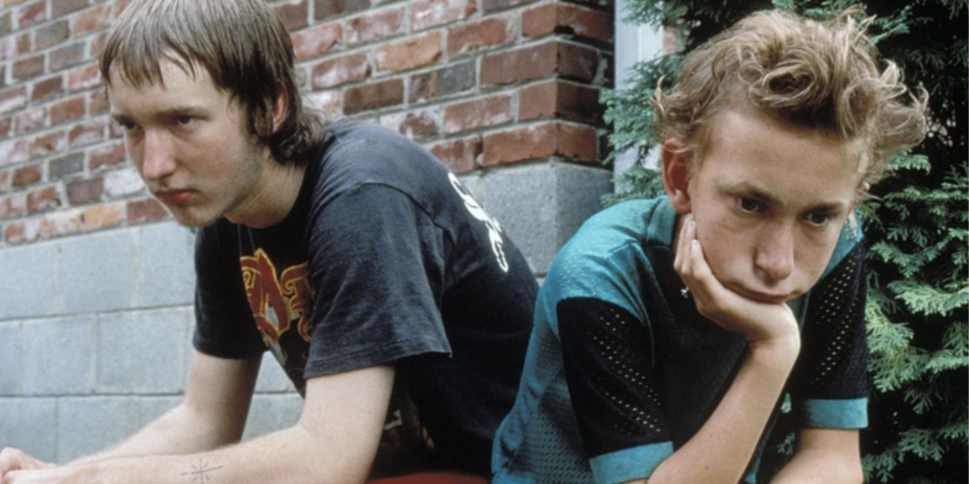 Two young boys sitting outside looking bored in Gummo