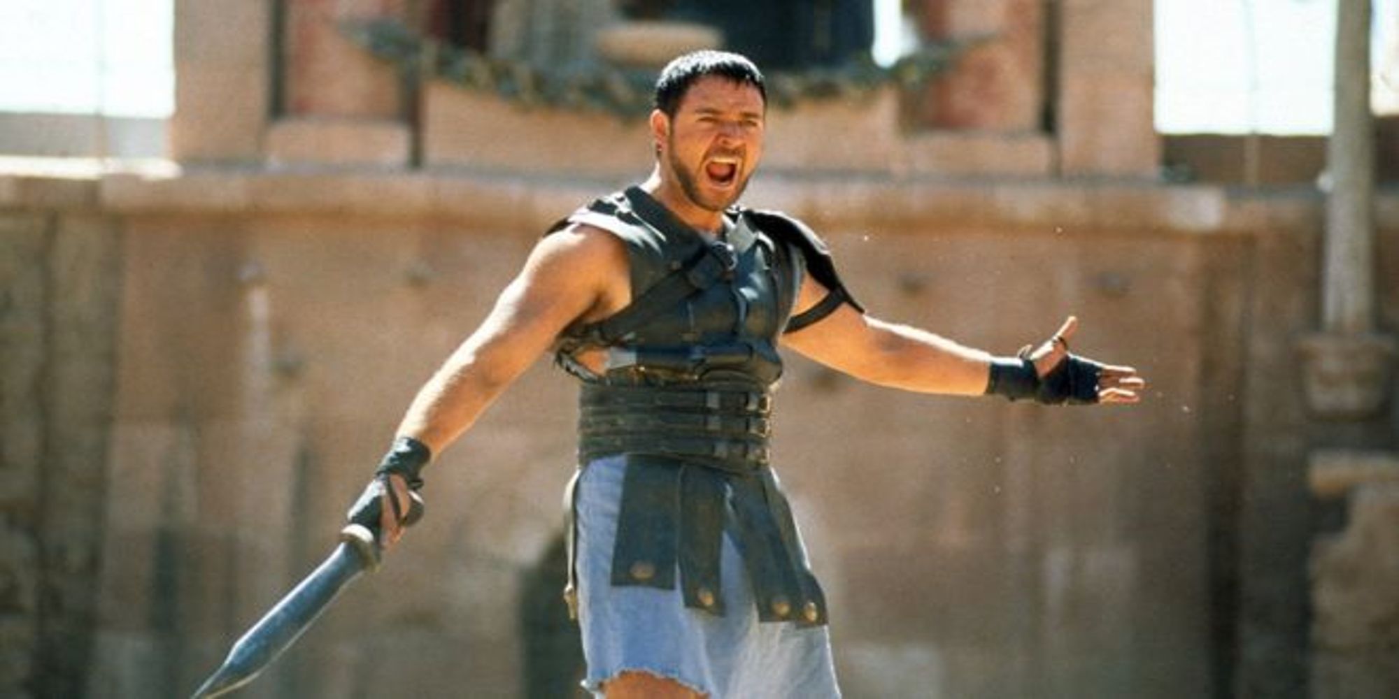 Maximus criant et écartant les bras en tenant une épée dans Gladiator.