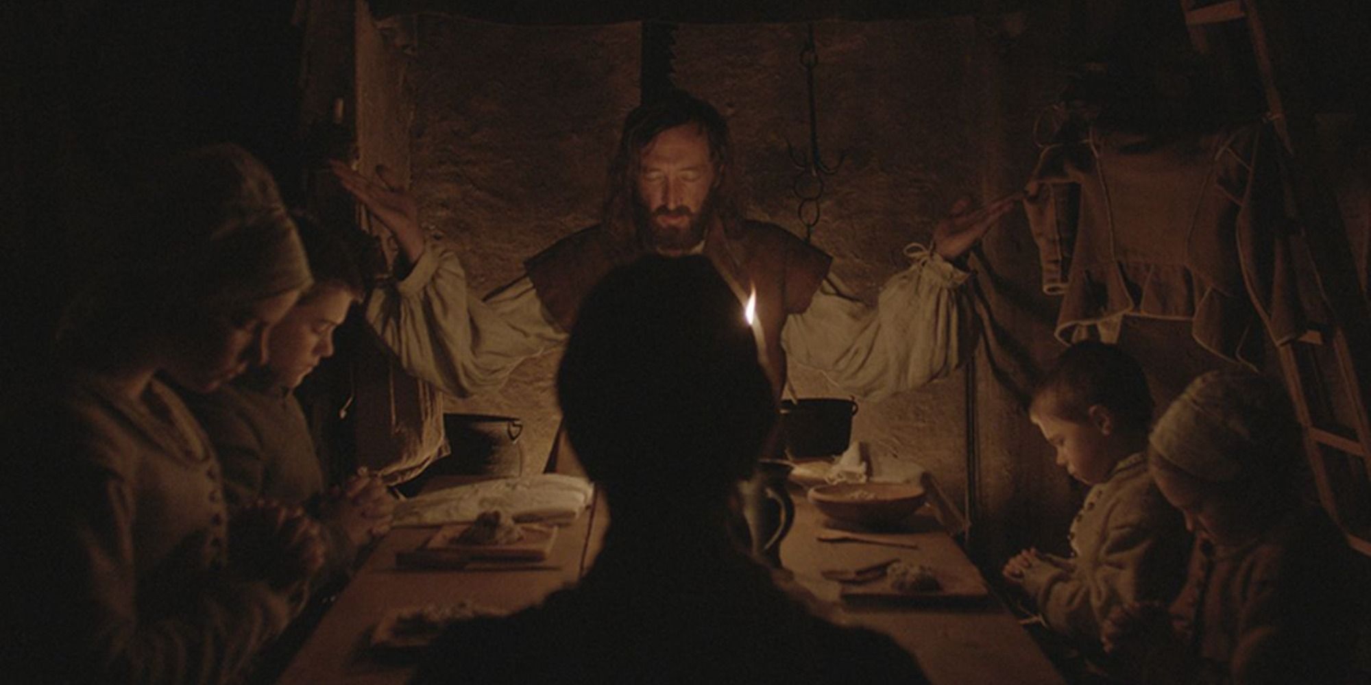 A family praying at the dinnertable in The VVitch