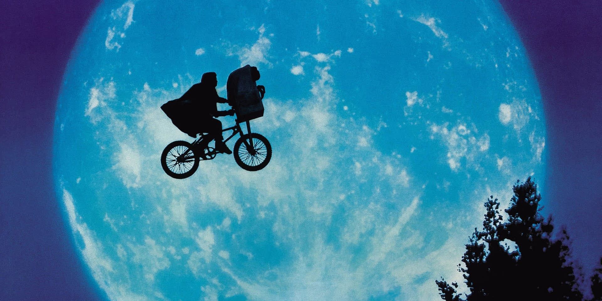 The silhouette of Elliott and E.T. flying on a bike in front of the moon in E.T.
