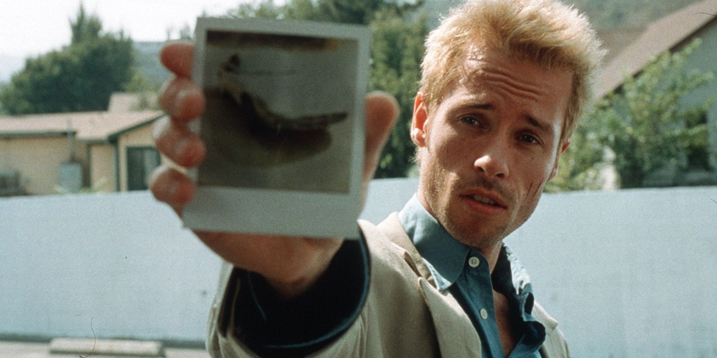 Guy Pearce as Leonard Shelby, holding out a polaroid in Memento