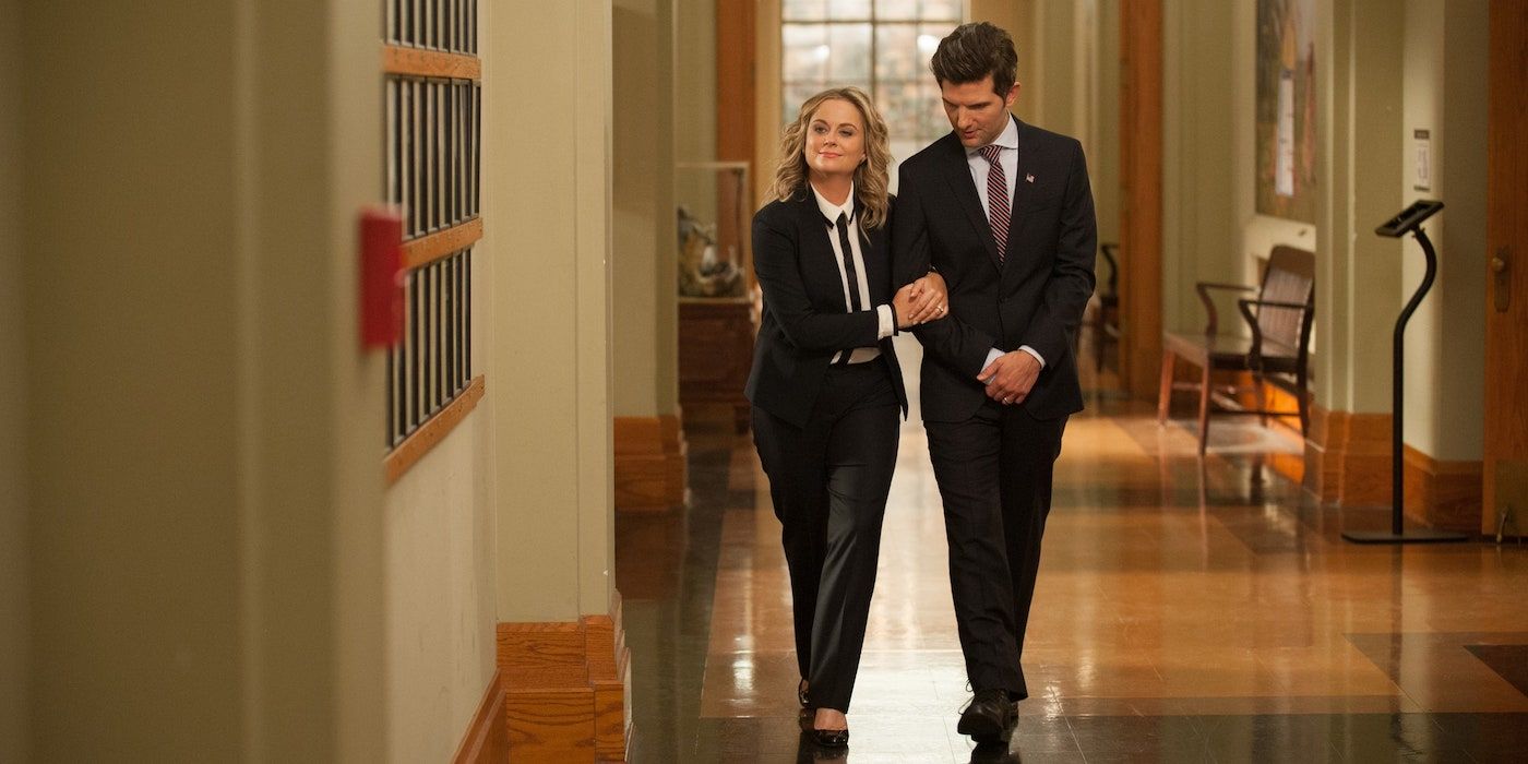 Leslie and Ben walk arm in arm down an empty hallway in City Hall in Parks and Recreation.